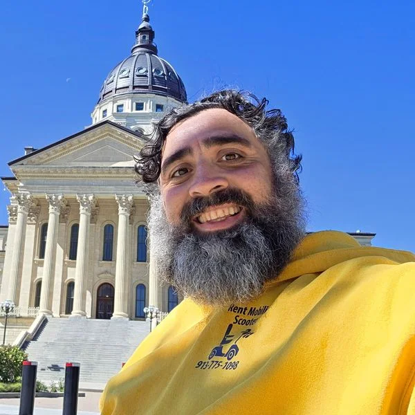Jeff in a KC Mobility hoodie in front of the Kansas State Capitol.