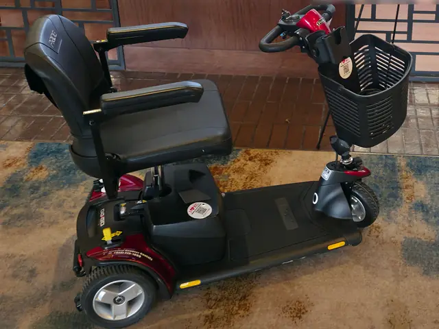 Red Pride Go-Go Sport 3-wheel mobility scooter from KC Mobility Scooter Rentals, set up indoors at a Kansas City venue