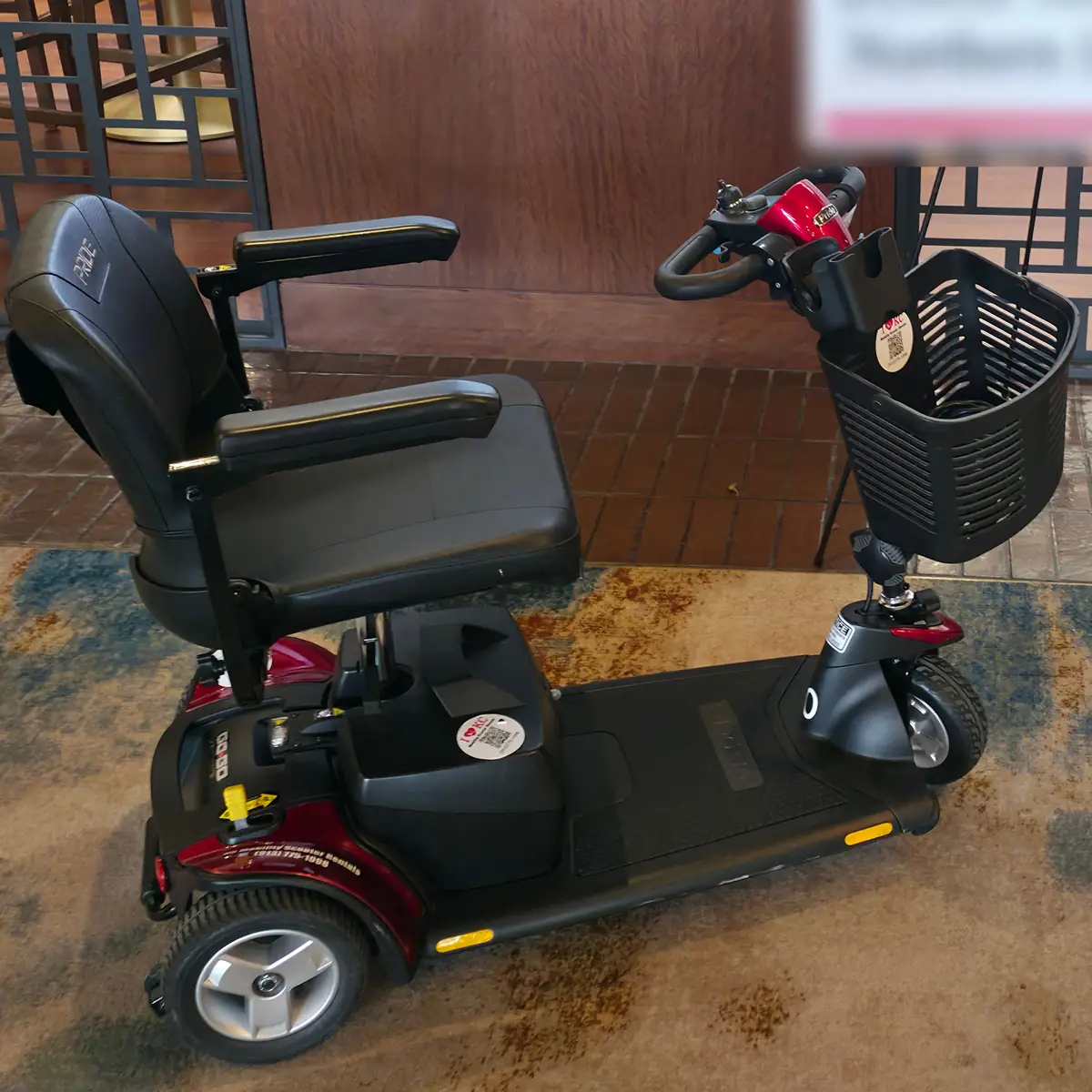 Red Pride Go-Go Sport 3-wheel mobility scooter from KC Mobility Scooter Rentals, set up indoors at a Kansas City venue