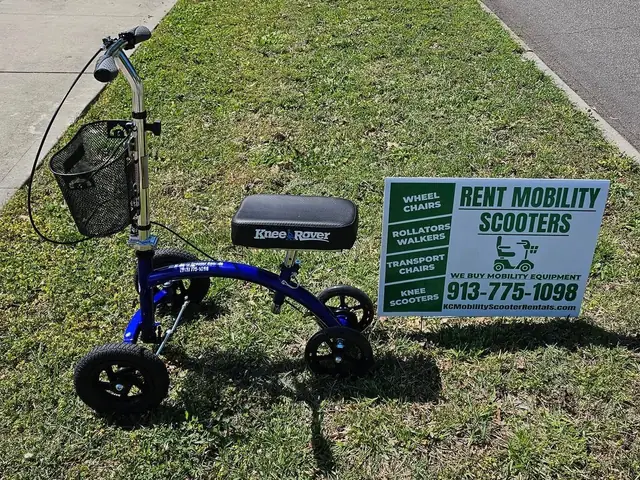Blue KneeRover Hybrid knee scooter from KC Mobility Scooter Rentals on the grass beside our rent mobility scooters yard sign