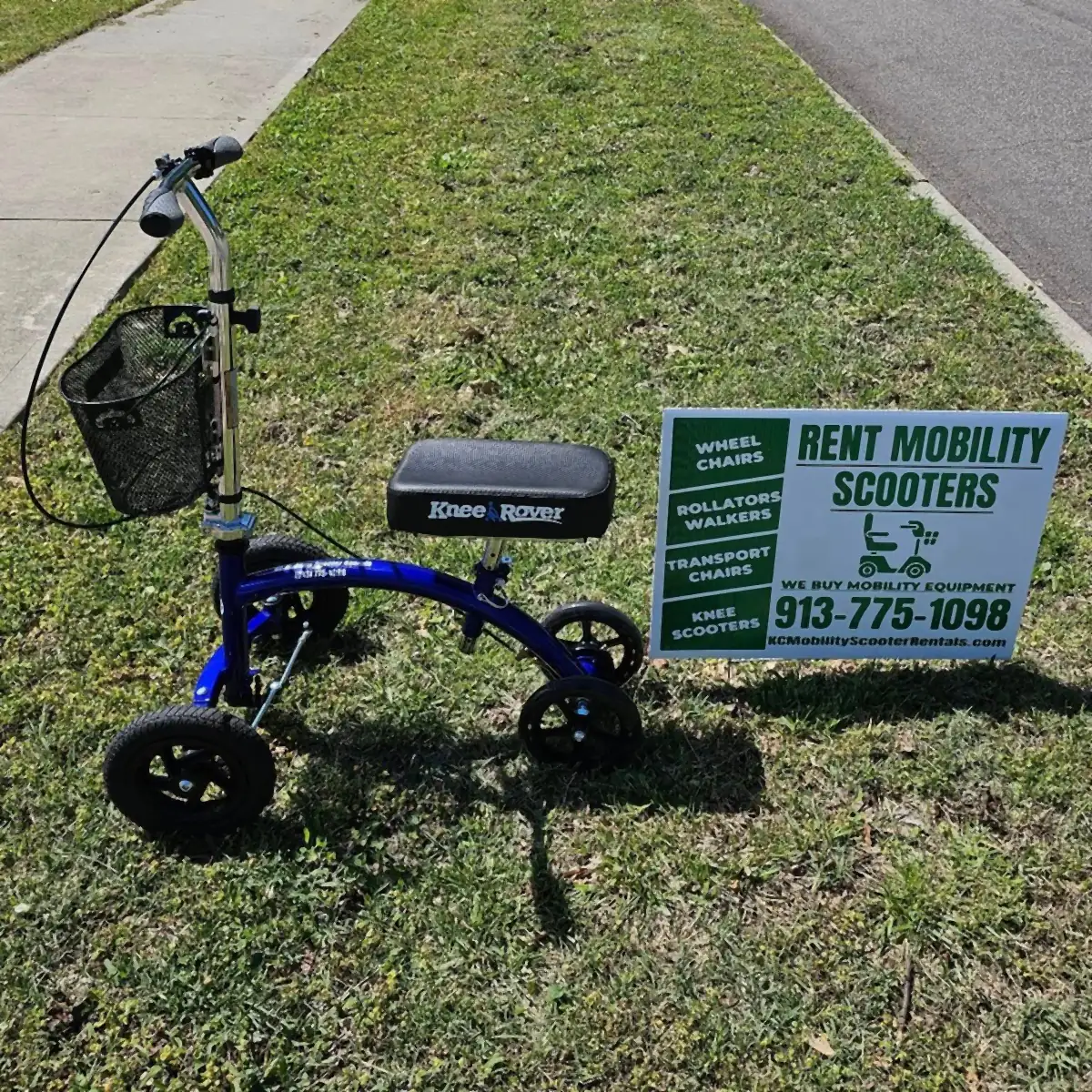 Blue KneeRover Hybrid knee scooter from KC Mobility Scooter Rentals on the grass beside our rent mobility scooters yard sign