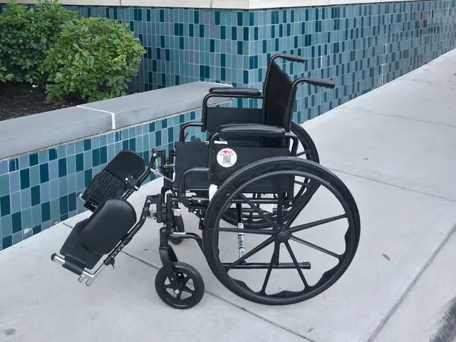 20-inch-seat manual wheelchair with elevating leg rests from KC Mobility Scooter Rentals below a blue fountain KC heart sculpture in Kansas City