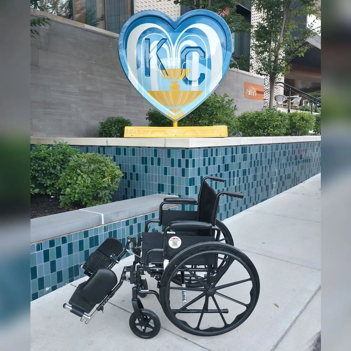 20-inch-seat manual wheelchair with elevating leg rests from KC Mobility Scooter Rentals below a blue fountain KC heart sculpture in Kansas City