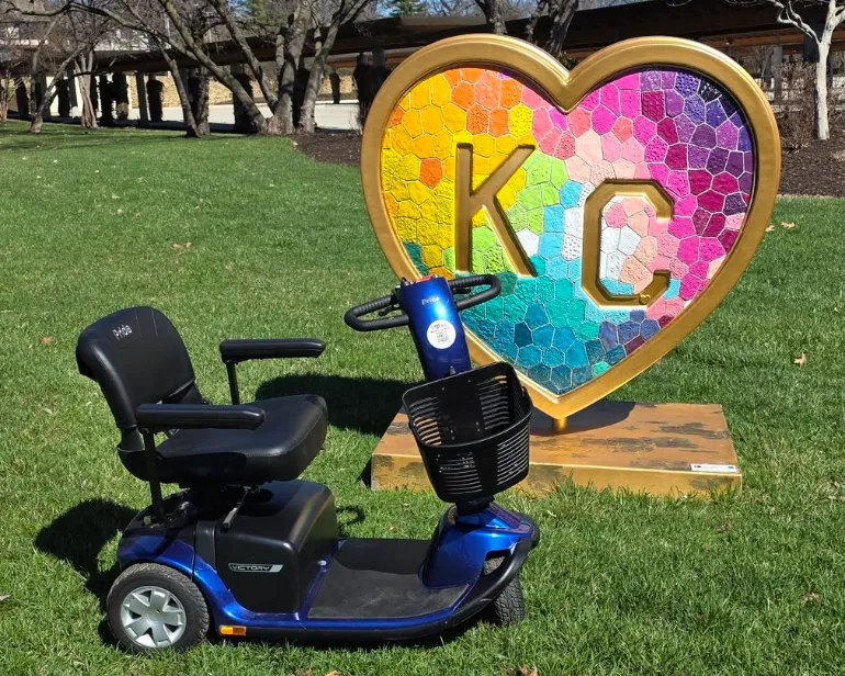 Pride Victory 10 mobility scooter staged in front of the rainbow KC heart sculpture in a Kansas City park
